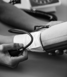 blood pressure cuff on arm black and white photo