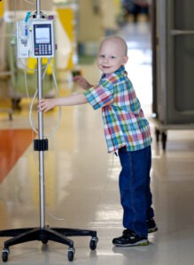 Child with IV pole child has no hair